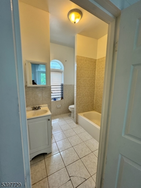 a bathroom with a granite countertop sink and a bathtub