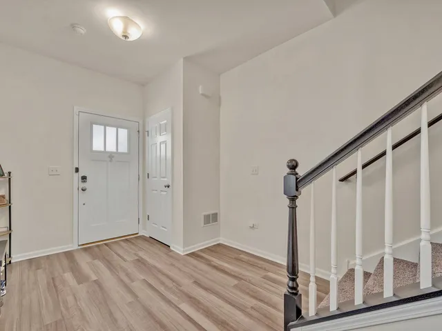 a view of front door with wooden floor and stairs