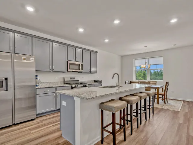 a kitchen with appliances a table and chairs in it
