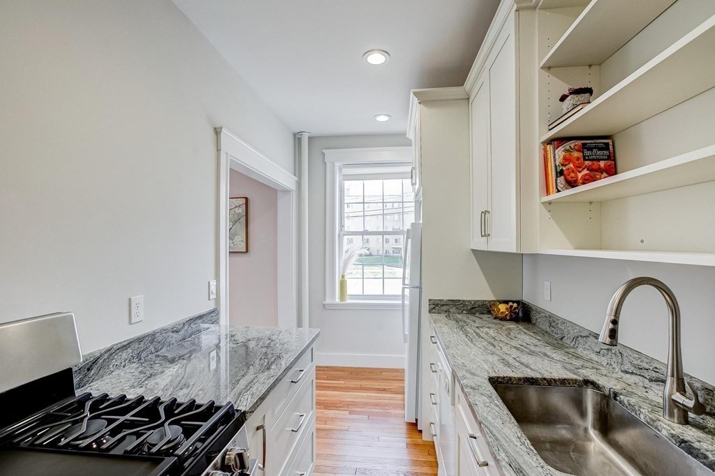 230 Massachusetts Avenue, Unit 2 Arlington, MA 02474 - Photo 11 of 25 a kitchen with granite countertop a stove and a sink