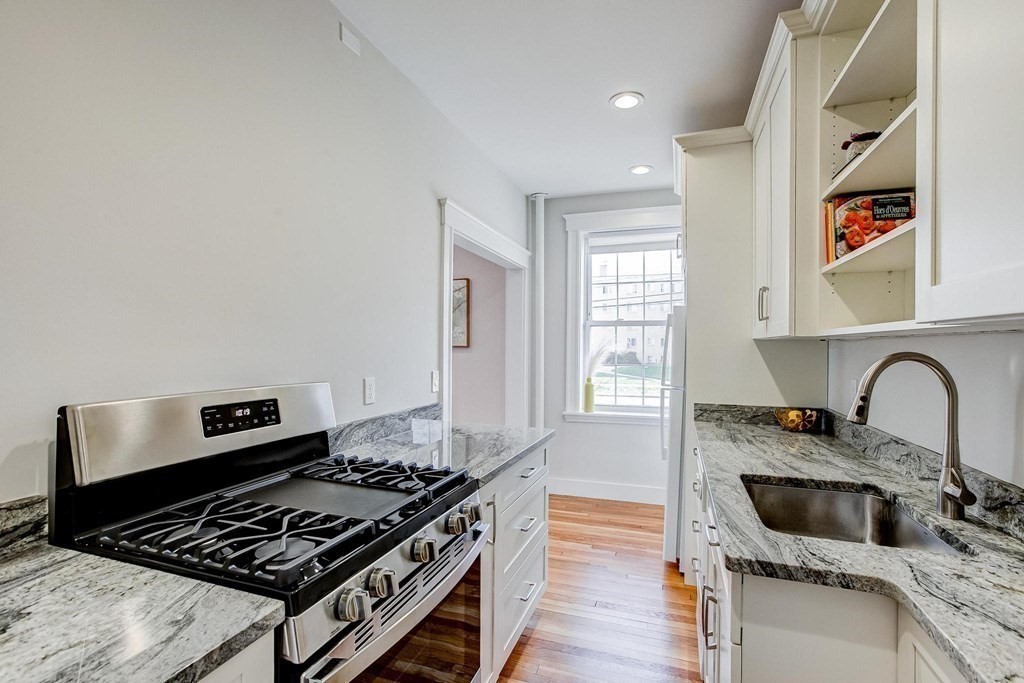 230 Massachusetts Avenue, Unit 2 Arlington, MA 02474 - Photo 12 of 25 a kitchen with granite countertop a stove and a sink
