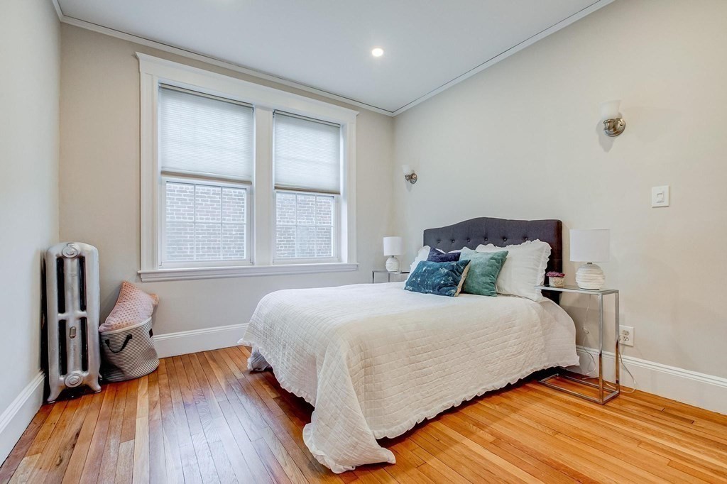 230 Massachusetts Avenue, Unit 2 Arlington, MA 02474 - Photo 14 of 25 a bedroom with a bed and a wooden floor