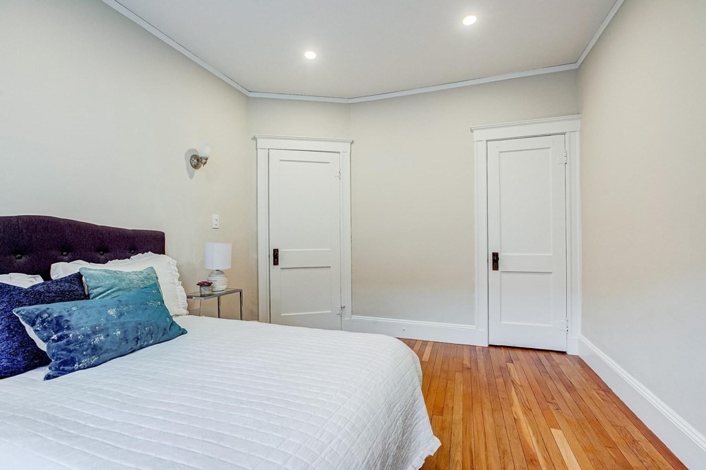 230 Massachusetts Avenue, Unit 2 Arlington, MA 02474 - Photo 15 of 25 a bedroom with a bed and wooden floor