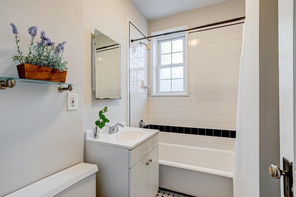 230 Massachusetts Avenue, Unit 2 Arlington, MA 02474 - Photo 16 of 25 a bathroom with a bathtub sink and mirror