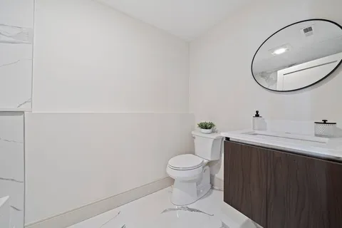 a bathroom with a sink a toilet and a mirror