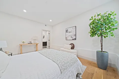 a bedroom with a bed and a potted plant