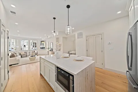 a large kitchen with kitchen island a sink appliances and a counter top space