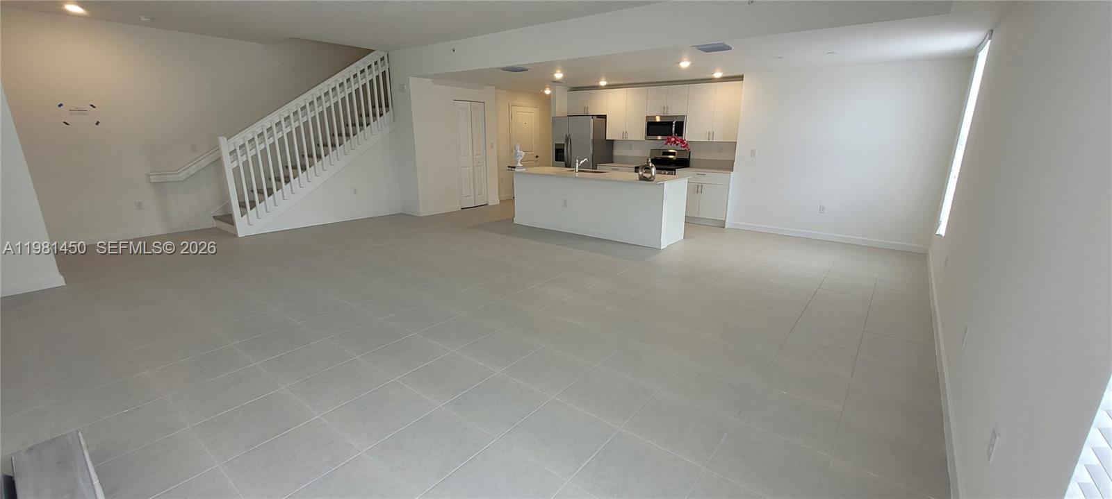 12470 Southwest 248th Street, Unit 5 Homestead, FL 33032 - Photo 4 of 18 a view of a livingroom with kitchen and staircase