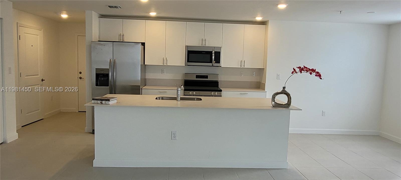 12470 Southwest 248th Street, Unit 5 Homestead, FL 33032 - Photo 8 of 18 a room with furniture a flat screen tv and a refrigerator