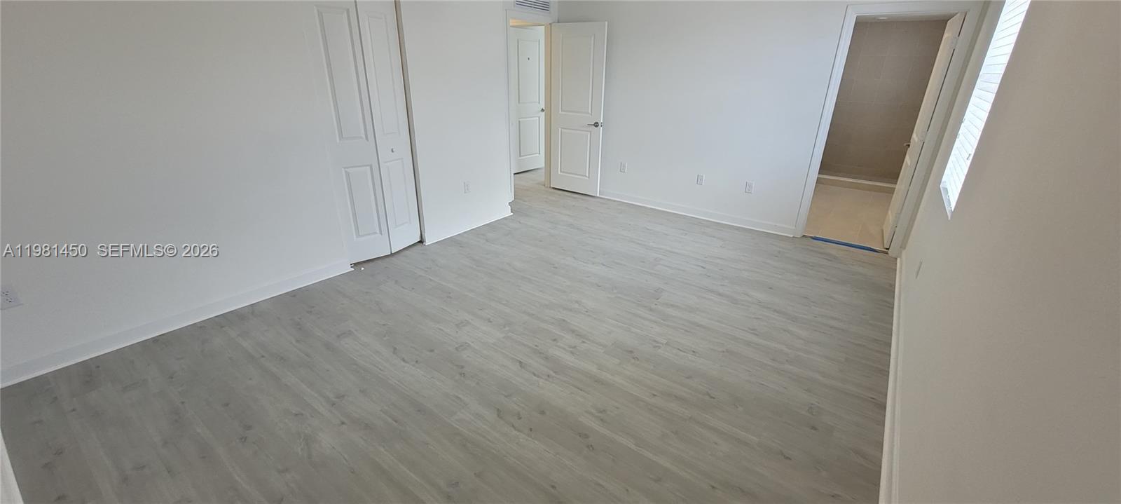 12470 Southwest 248th Street, Unit 5 Homestead, FL 33032 - Photo 10 of 18 an empty room with wooden floor