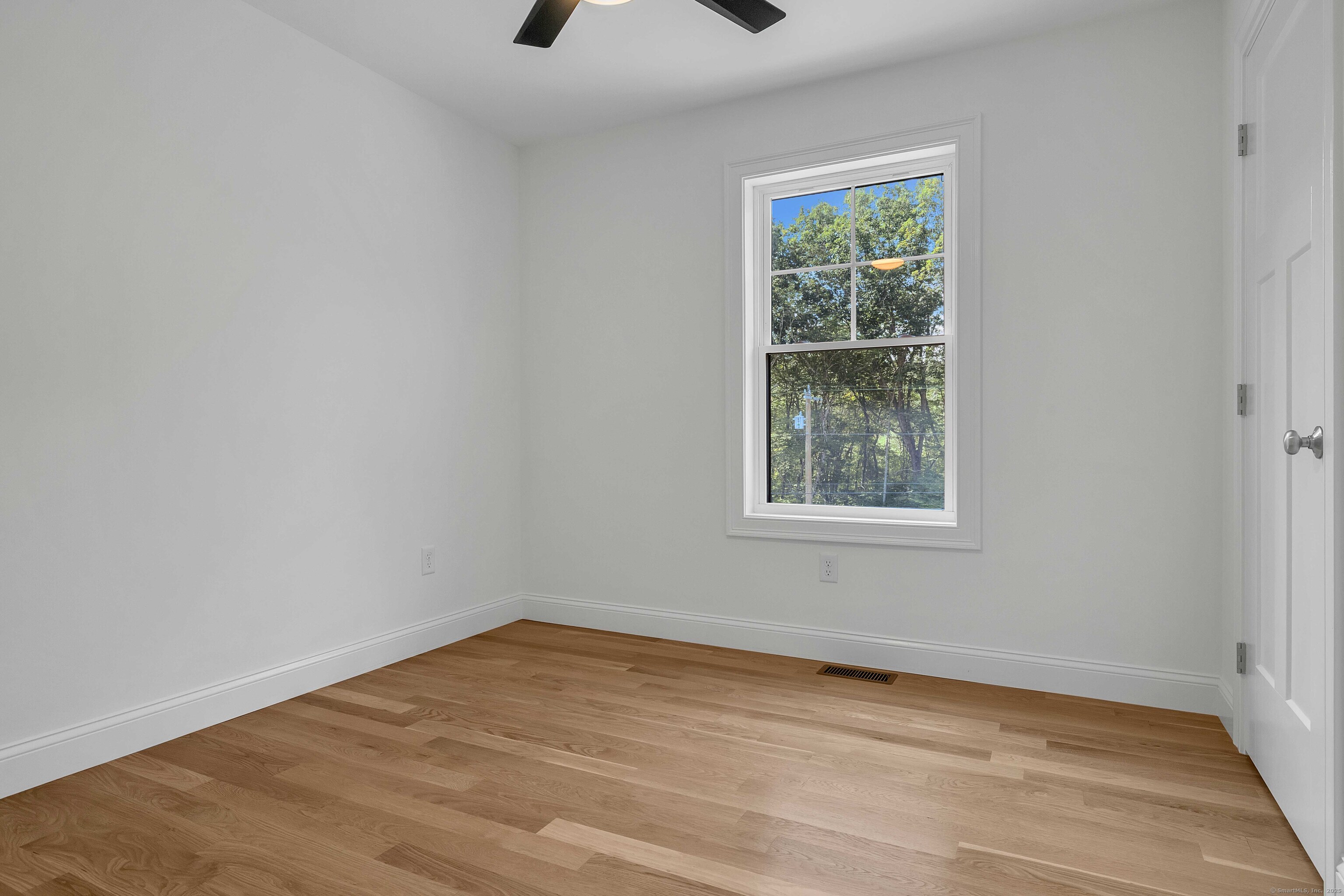 4 Lake Of Isles Road North Stonington, CT 06359 - Photo 15 of 23 a view of an empty room with a window and wooden floor