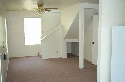 a view of a room with white walls and stairs