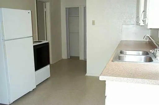 a kitchen with a refrigerator and a sink