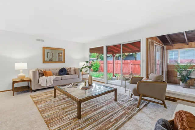 a living room with furniture a table and a large window