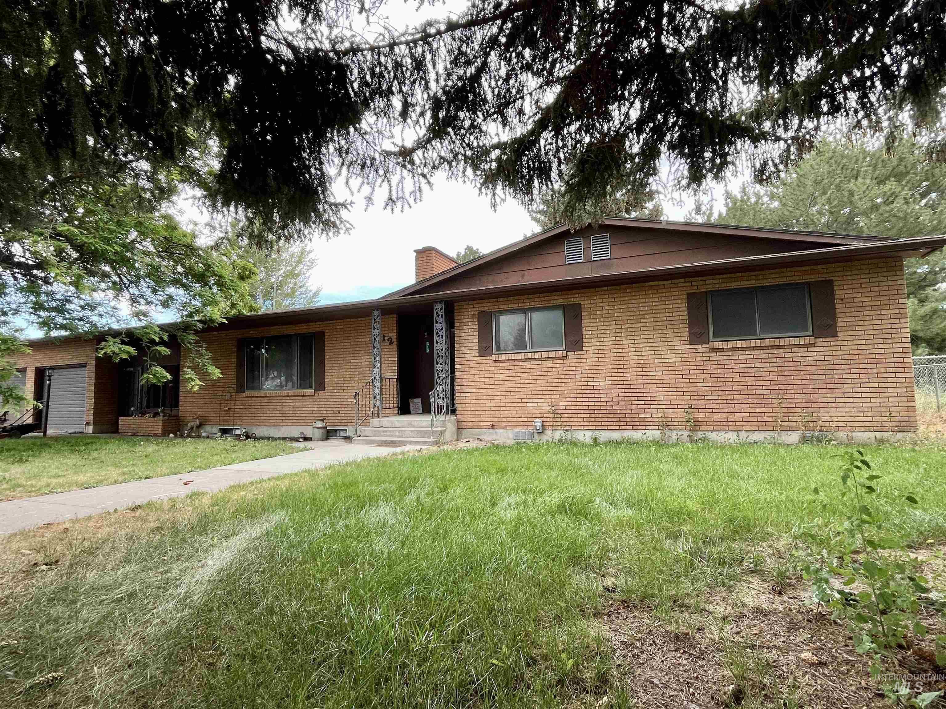 Ranch-style home with brick siding, a chimney, and a front lawn