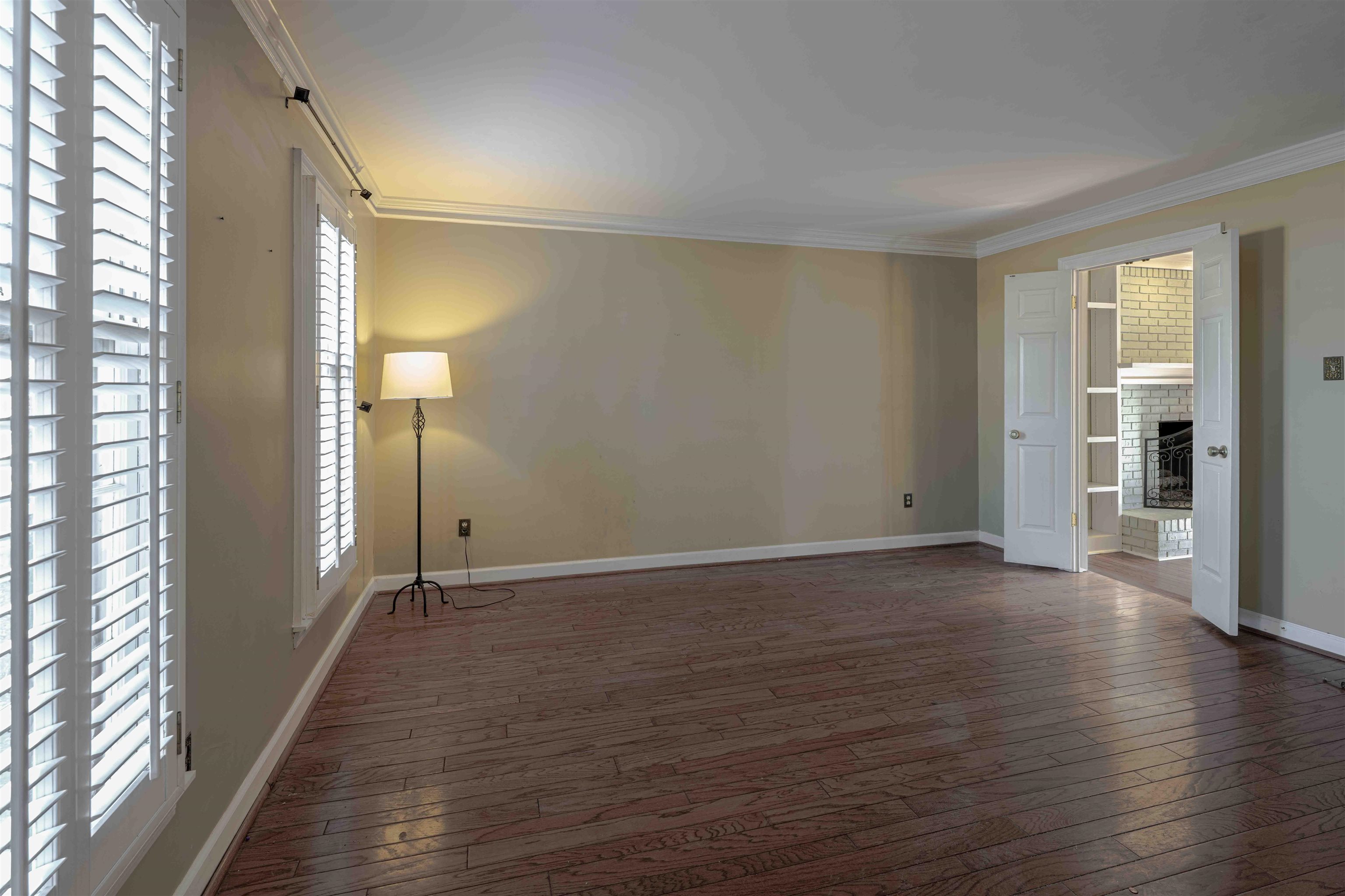 8883 Farmoor Road Germantown, TN 38139 - Photo 14 of 34 Empty room with hardwood / wood-style floors, ornamental molding, and a fireplace