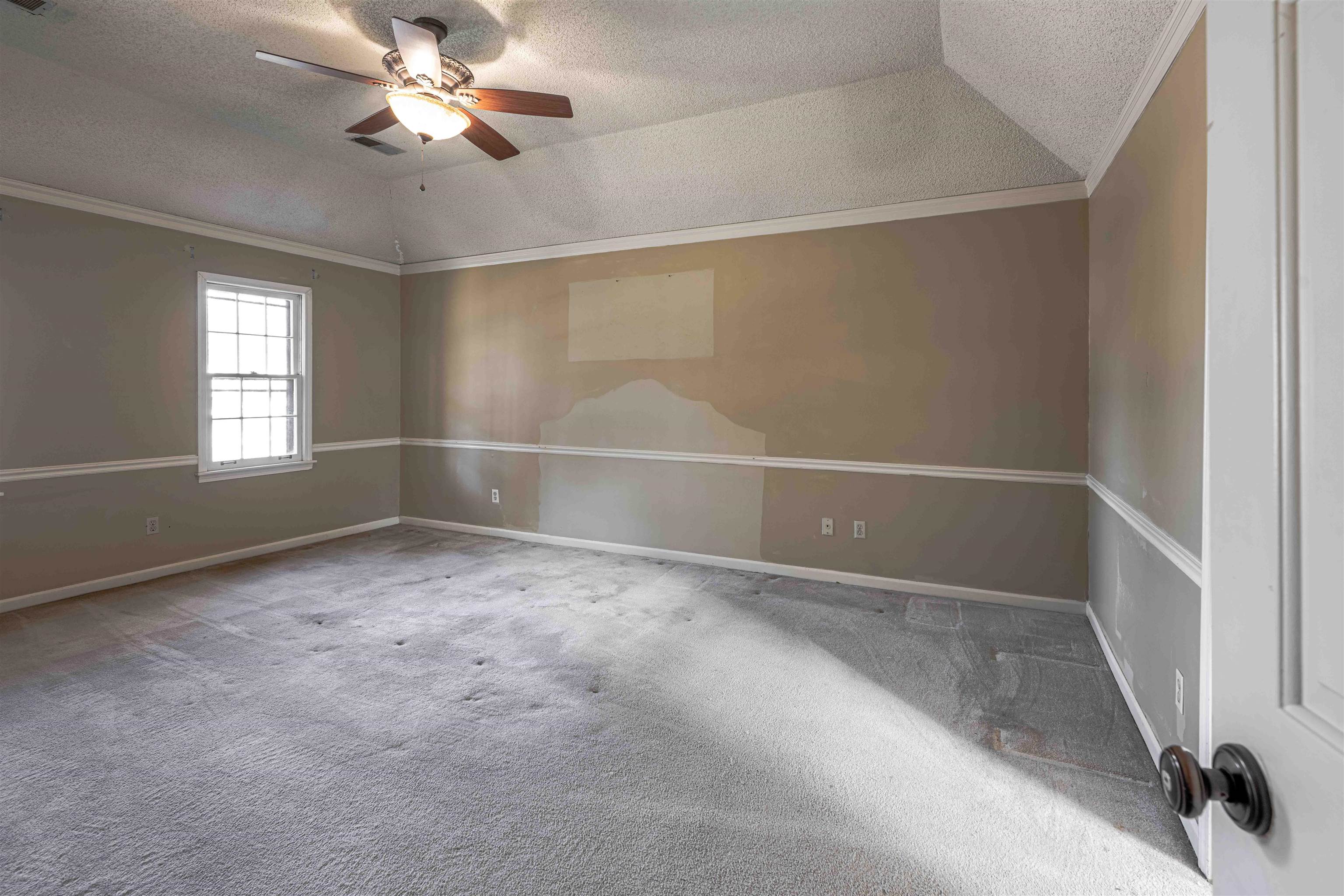 8883 Farmoor Road Germantown, TN 38139 - Photo 21 of 34 Empty room featuring lofted ceiling, crown molding, a textured ceiling, carpet floors, and a ceiling fan