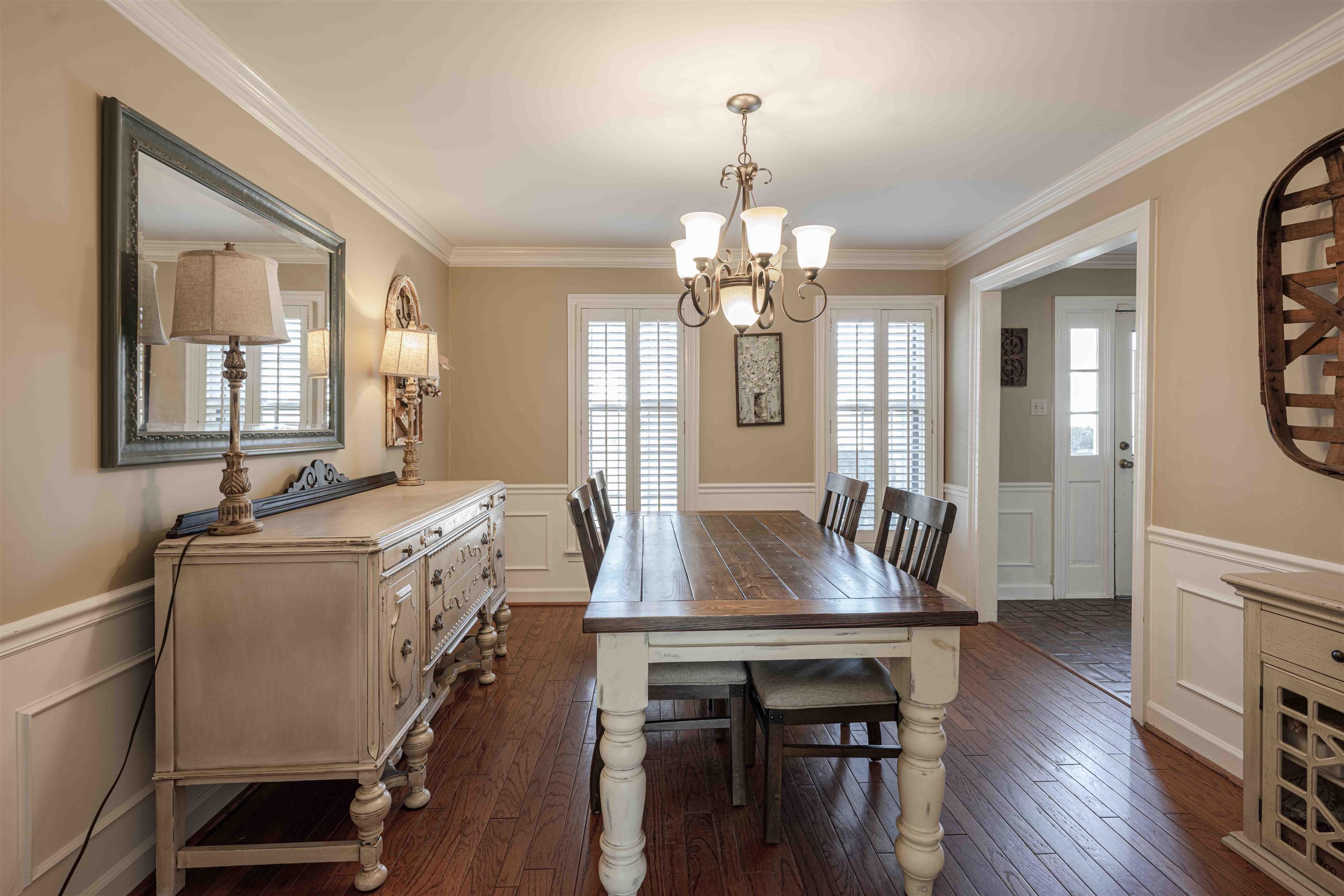 8883 Farmoor Road Germantown, TN 38139 - Photo 6 of 34 Dining area with a wainscoted wall, a decorative wall, dark wood finished floors, plenty of natural light, and a chandelier
