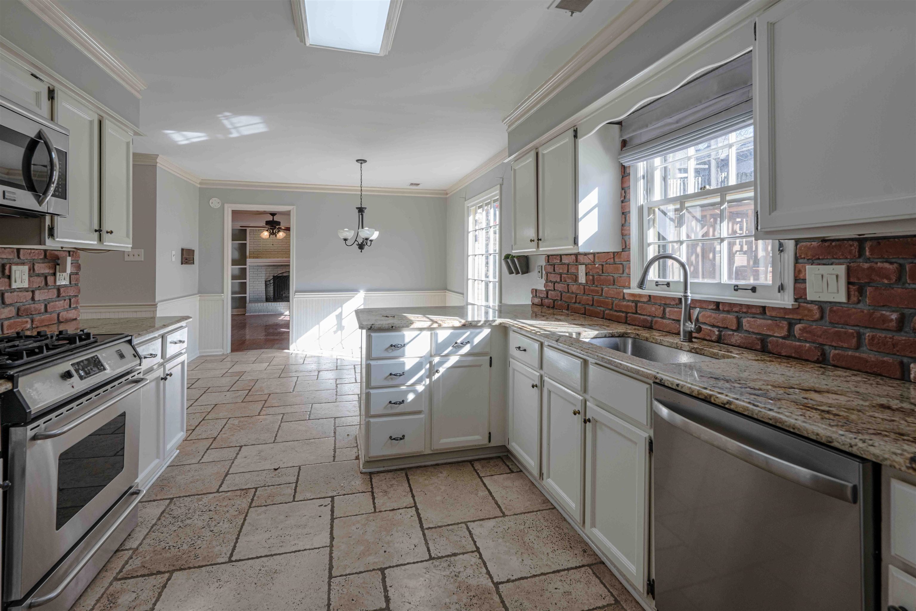 8883 Farmoor Road Germantown, TN 38139 - Photo 8 of 34 Kitchen with a wainscoted wall, a peninsula, appliances with stainless steel finishes, white cabinetry, and ceiling fan