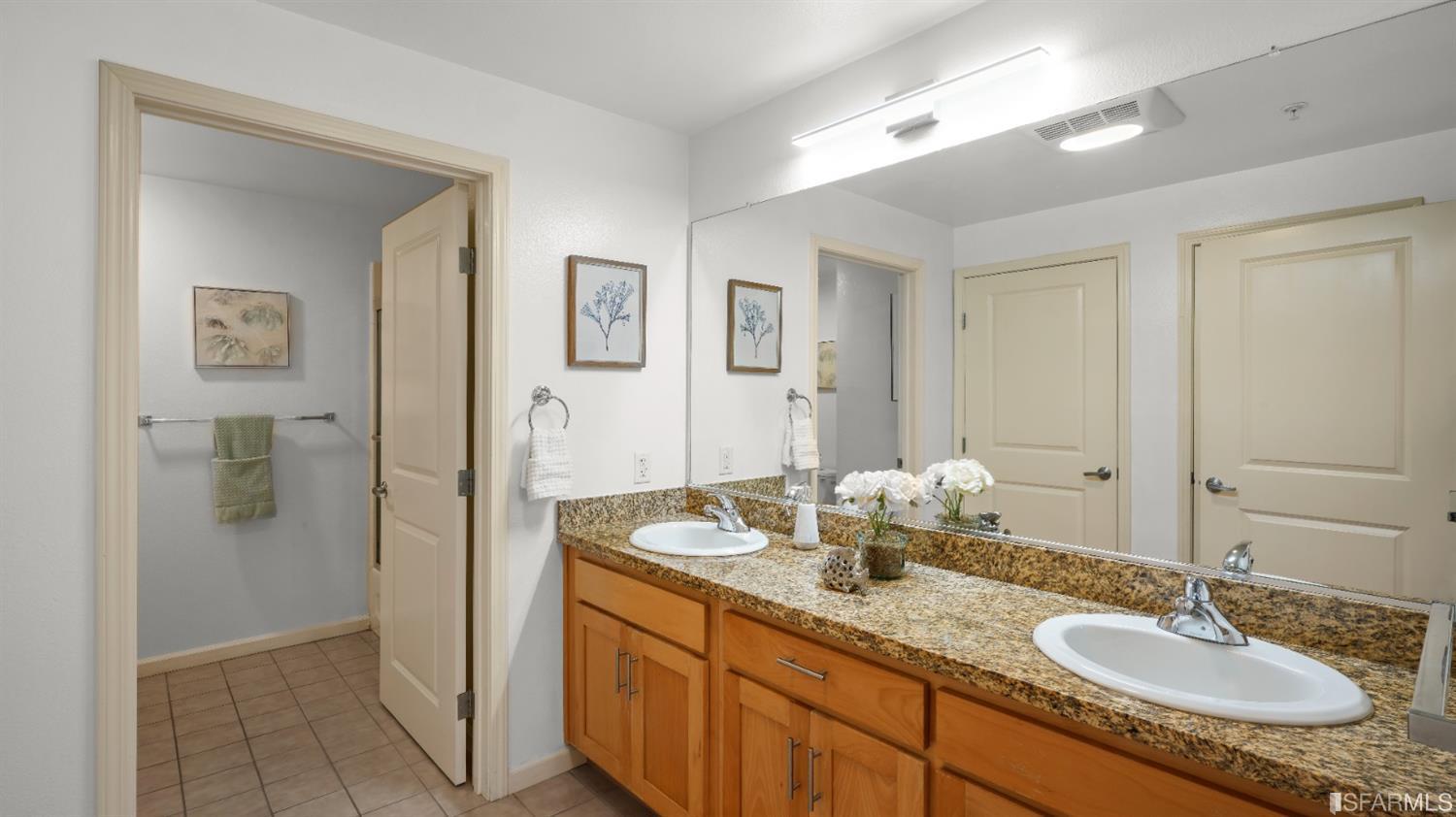 301 Crescent Court, Unit 3117 San Francisco, CA 94134 - Photo 12 of 34 a bathroom with a granite countertop double vanity sink shower and a mirror
