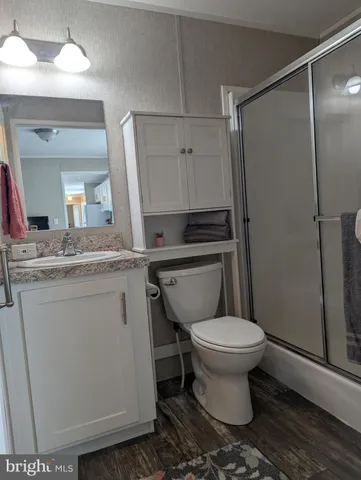 a bathroom with a granite countertop toilet sink and a mirror