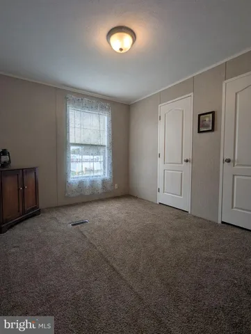 an empty room with a fan and a window