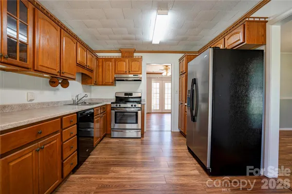 a view of a kitchen with a sink and wooden floor
