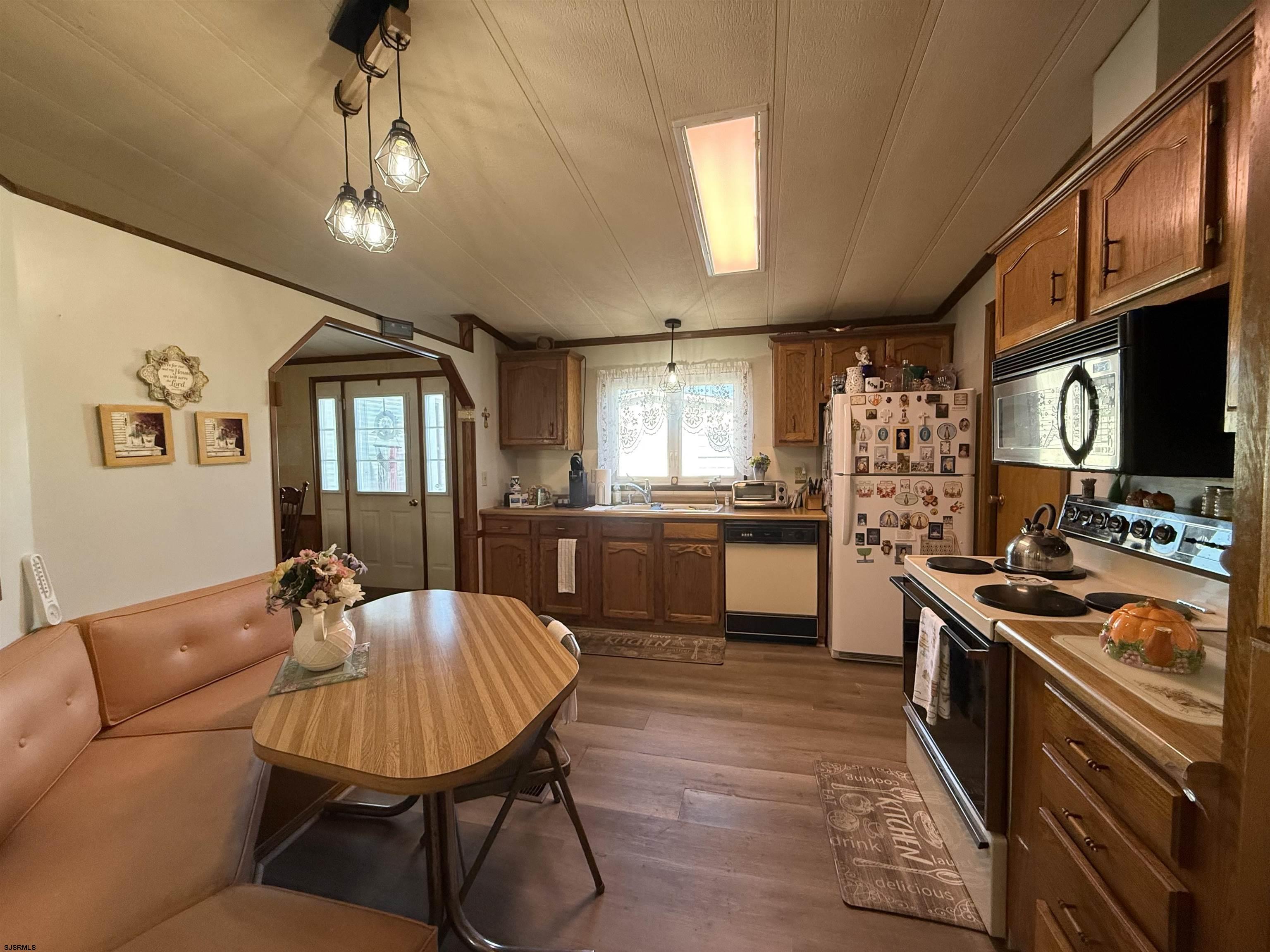 443 Priscilla Lane Buena, NJ 08310 - Photo 14 of 37 a kitchen with stainless steel appliances kitchen island granite countertop a sink refrigerator dining table and chairs