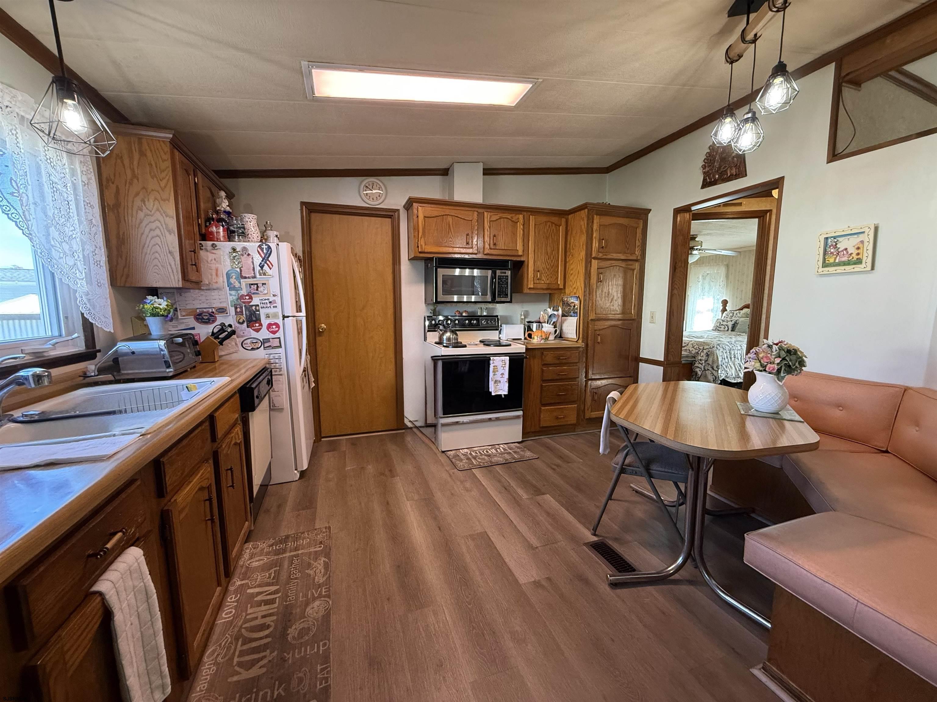 443 Priscilla Lane Buena, NJ 08310 - Photo 17 of 37 a kitchen with stainless steel appliances kitchen island granite countertop a table chairs in it and wooden floors