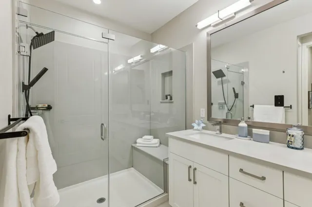 a bathroom with a shower sink and mirror