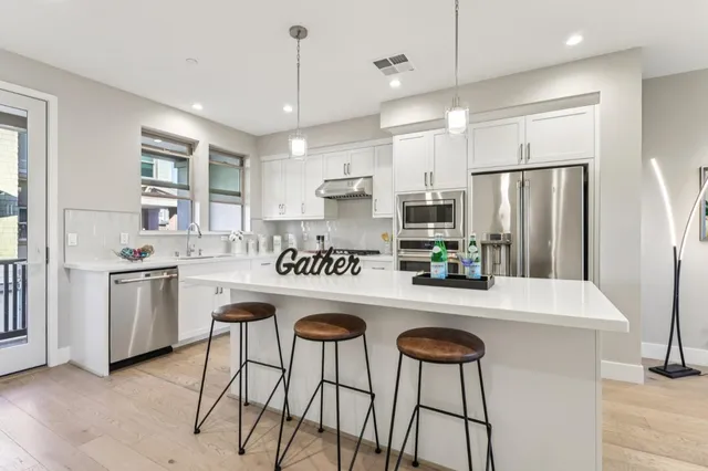a kitchen with stainless steel appliances kitchen island granite countertop a refrigerator and a stove top oven
