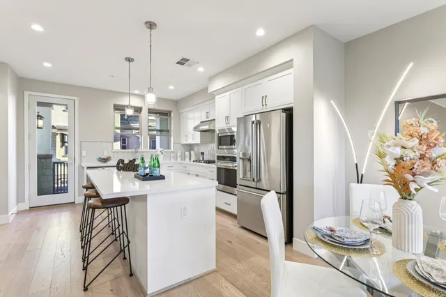 a kitchen with stainless steel appliances granite countertop a refrigerator and a stove top oven