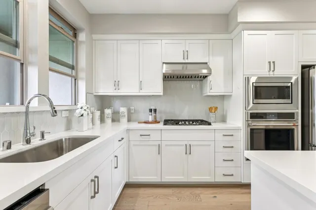 a kitchen with cabinets appliances a sink and a counter top space