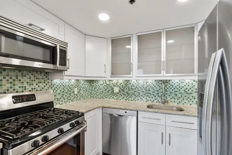 a kitchen with stainless steel appliances granite countertop a stove and a microwave