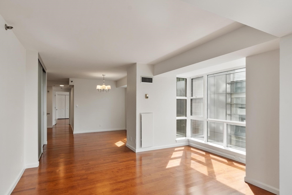 170 Tremont Street, Unit 504 Boston, MA 02111 - Photo 17 of 27 a view of an empty room with wooden floor and a window
