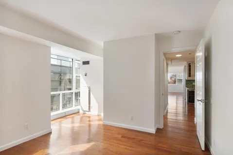 a view of empty room with wooden floor