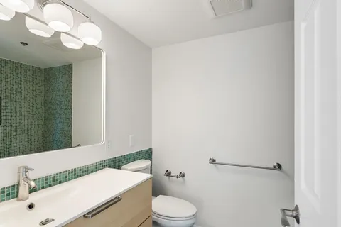 a bathroom with a sink a toilet and a mirror
