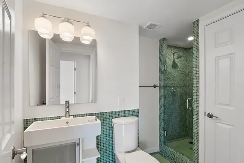 a bathroom with a sink a toilet and shower