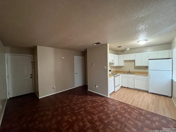a kitchen with a refrigerator and a stove top oven
