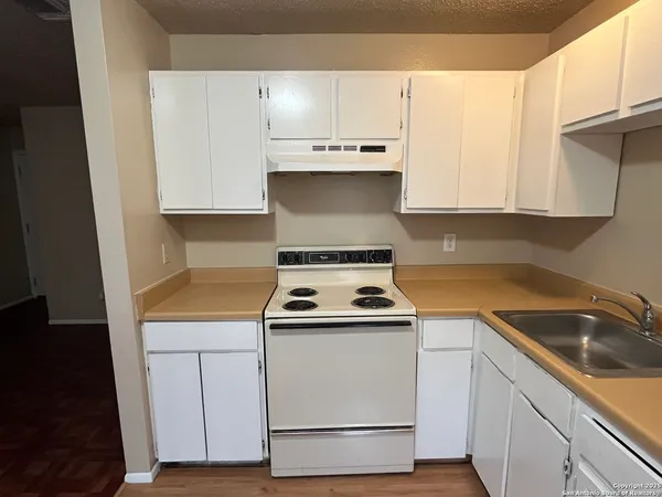 a kitchen with a sink a stove and cabinets