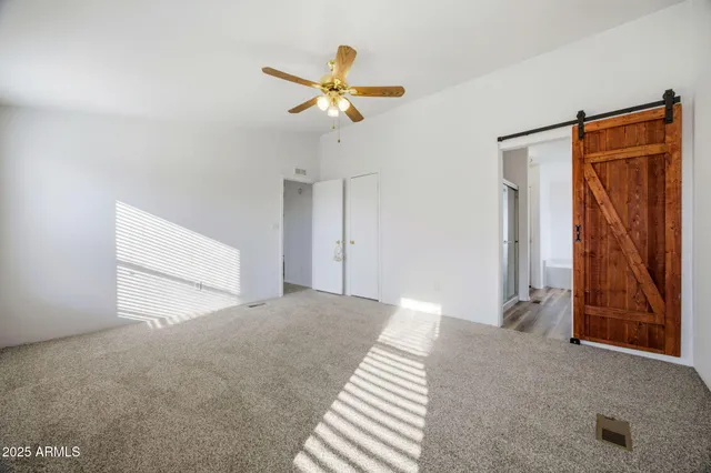 an empty room with a window and a fan