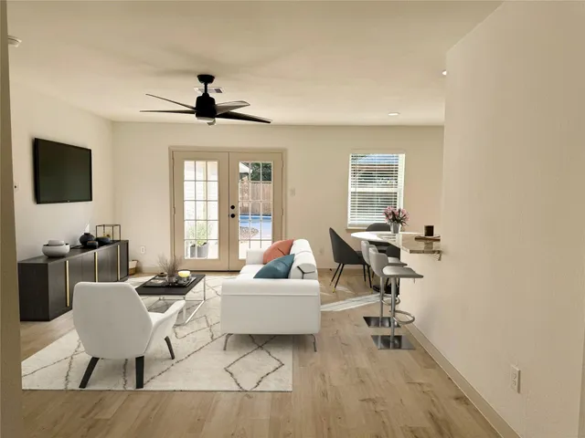 a living room with furniture a flat screen tv and a window