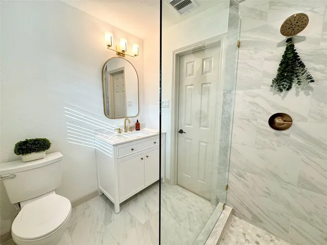 a bathroom with a toilet a sink and mirror