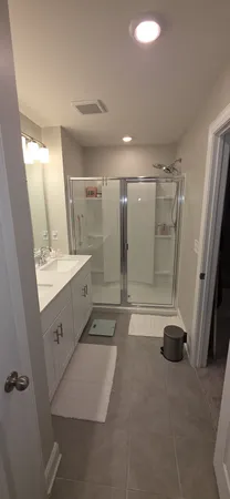 a bathroom with a double vanity sink a shower and a mirror