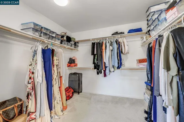 a view of walk in closet with clothes and shoes