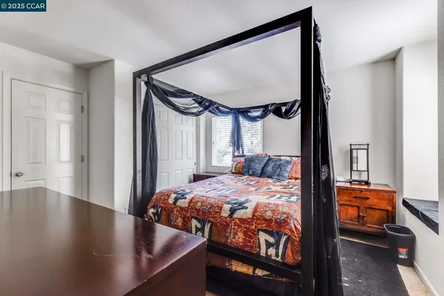 a bedroom with a bed a dresser and wooden floor