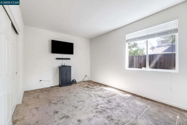 a view of a livingroom with an empty space and a window