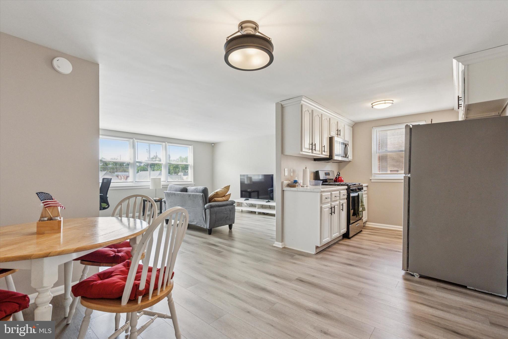120 Clement Road Oreland, PA 19075 - Photo 17 of 34 a kitchen with stainless steel appliances granite countertop a stove top oven a sink dishwasher and a dining table with wooden floor