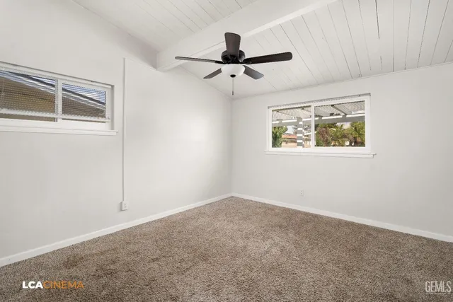 an empty room with wooden floor and ceiling fan