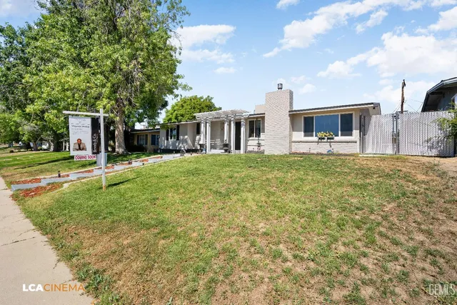 a view of a house with a yard and sitting area